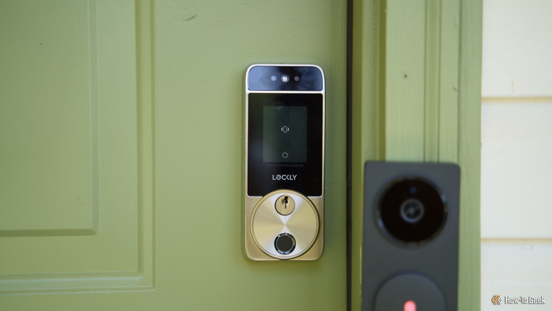 The Lockly Visage smart lock on a green door.