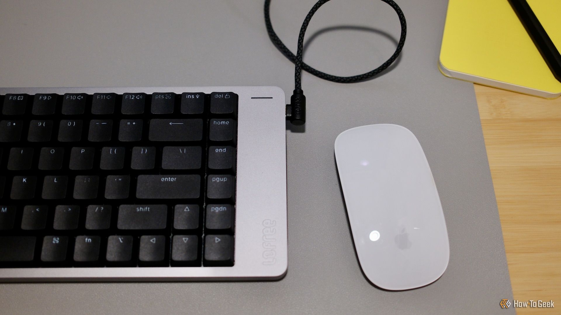 A close up of the right side of the Lofree Flow 2 with mouse to the right of it.