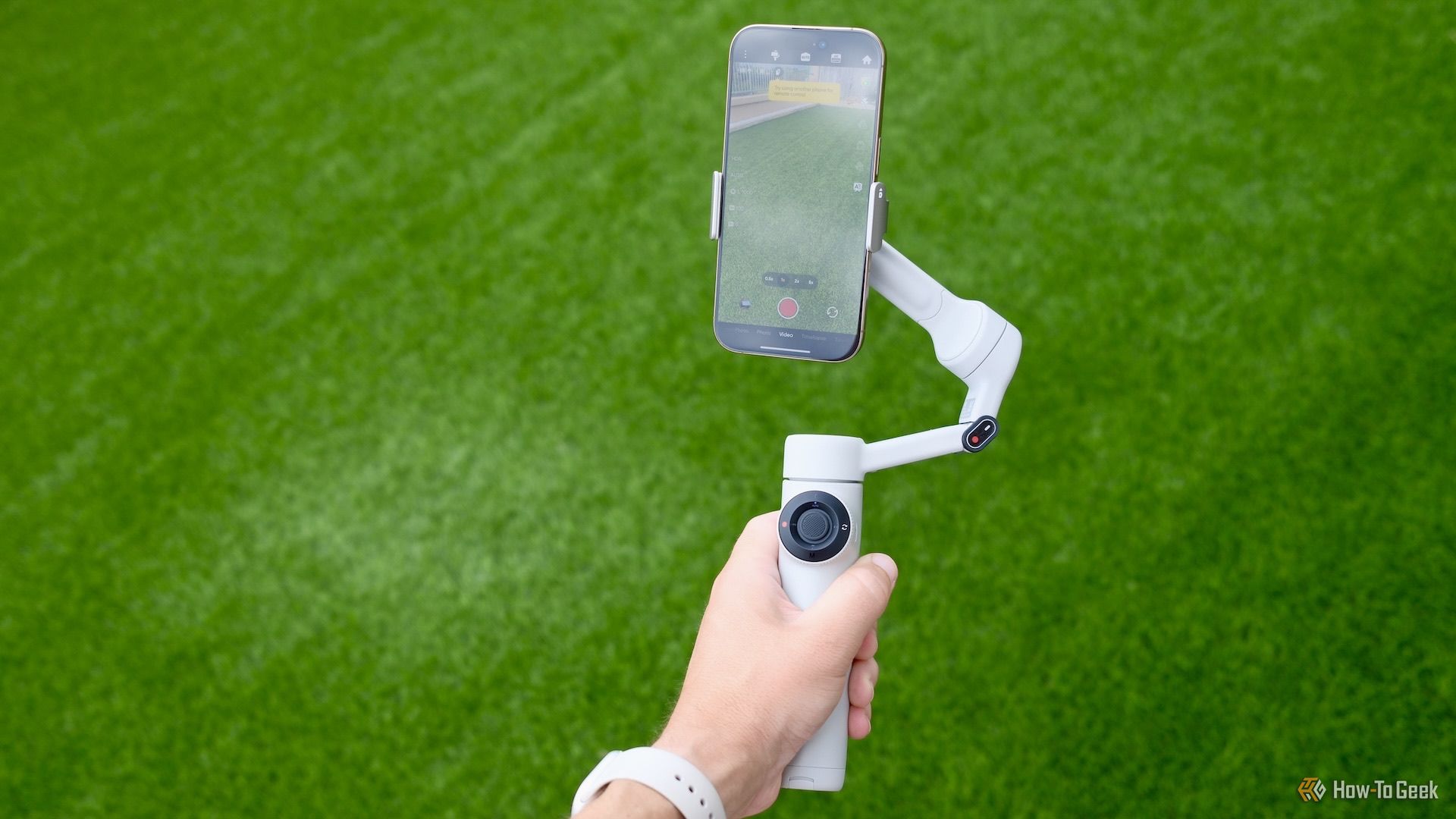 Hand hold the Insta360 Flow 2 outside.