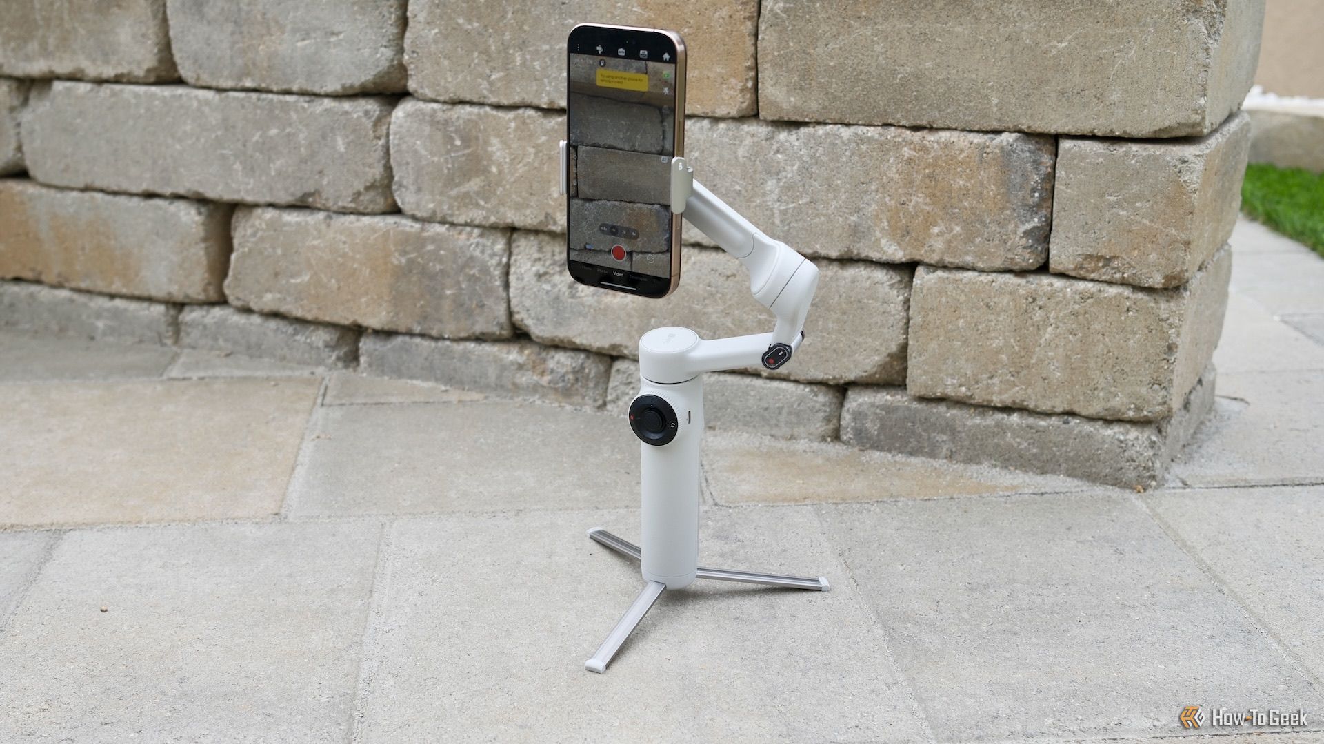 Insta360 Flow 2 outside free-standing with an iPhone connected.