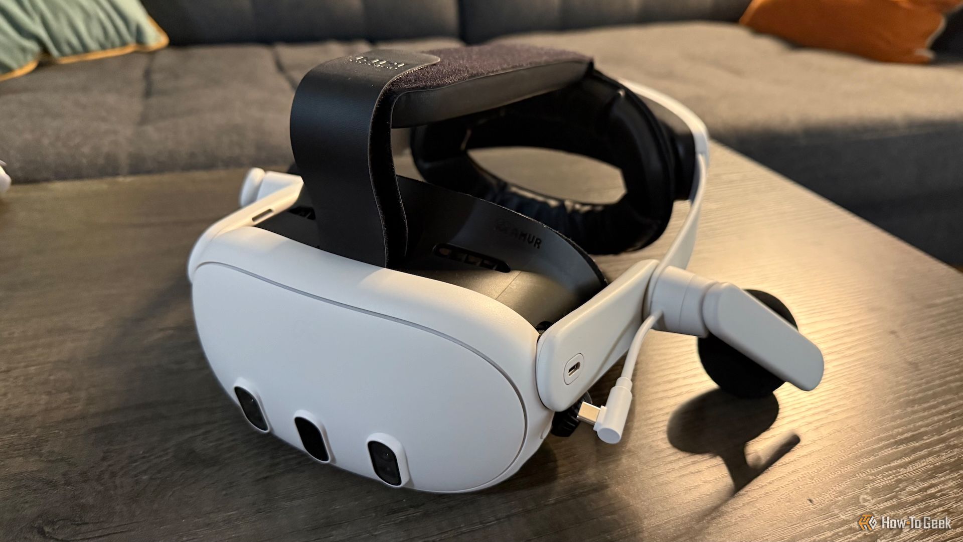 A Meta Quest 3 with a KIWI K4 Duo headphone strap attached to it on a table.