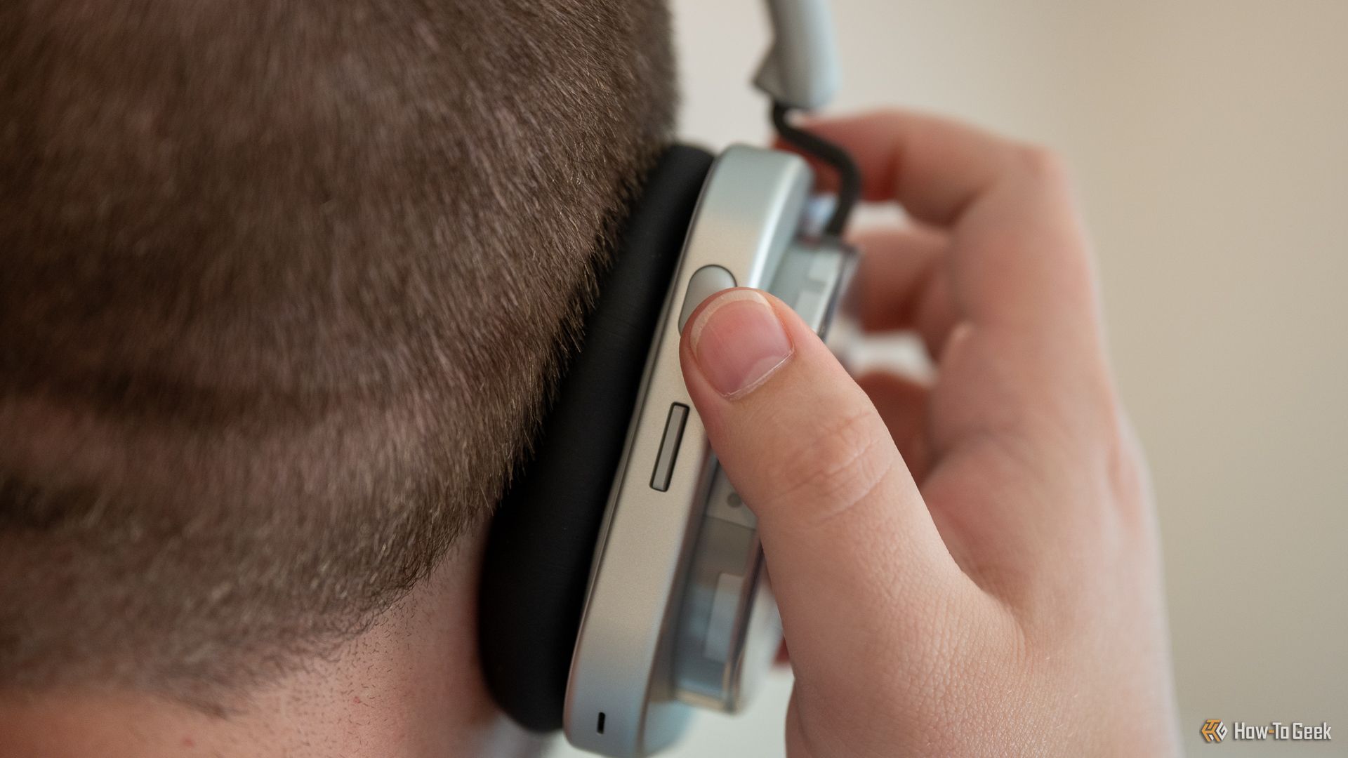 Person wearing the Nothing Headphone (1) and using the volume button.