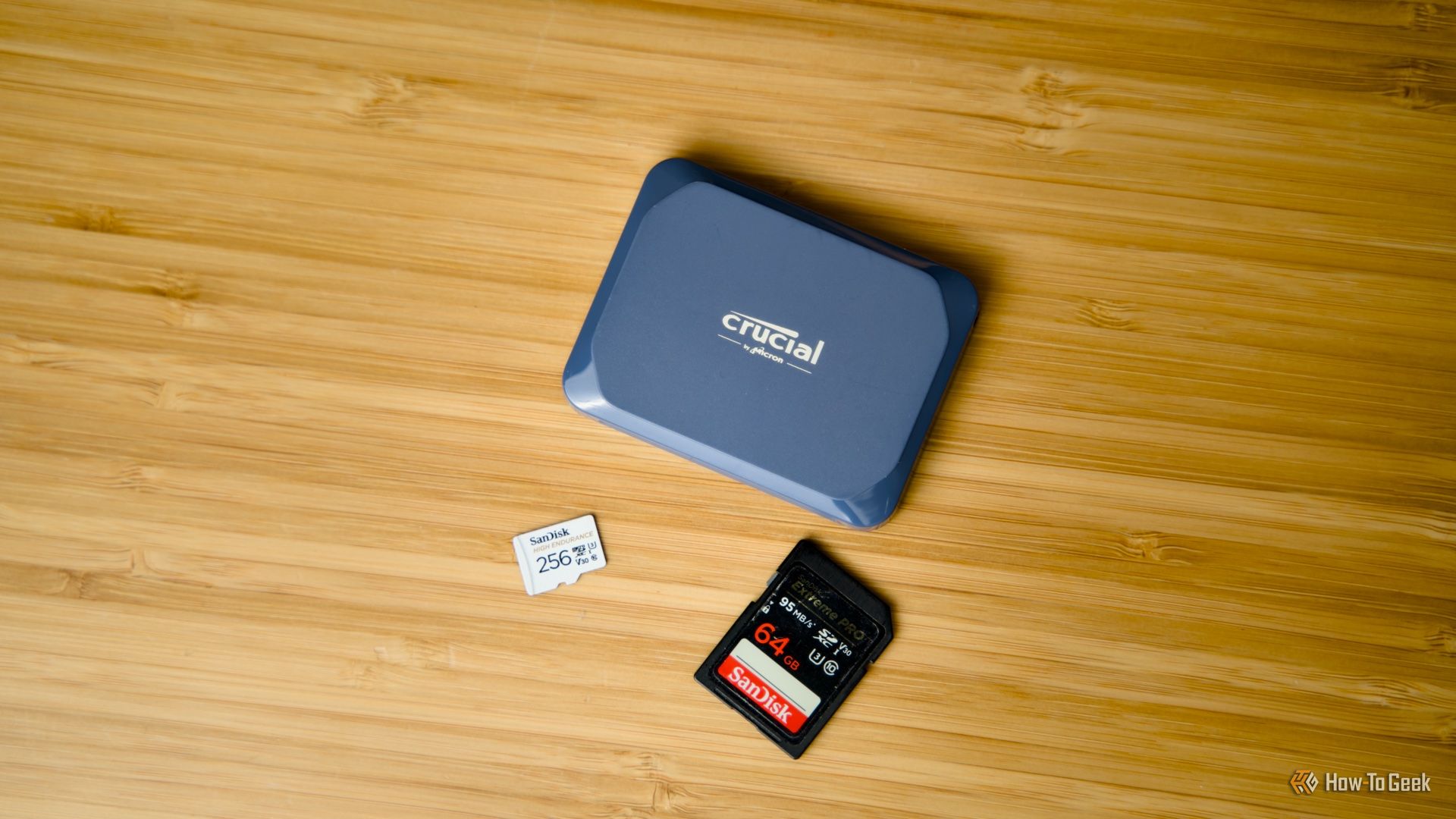 The Crucial X10 portable SSD next to an SD card and microSD card showing the size difference.