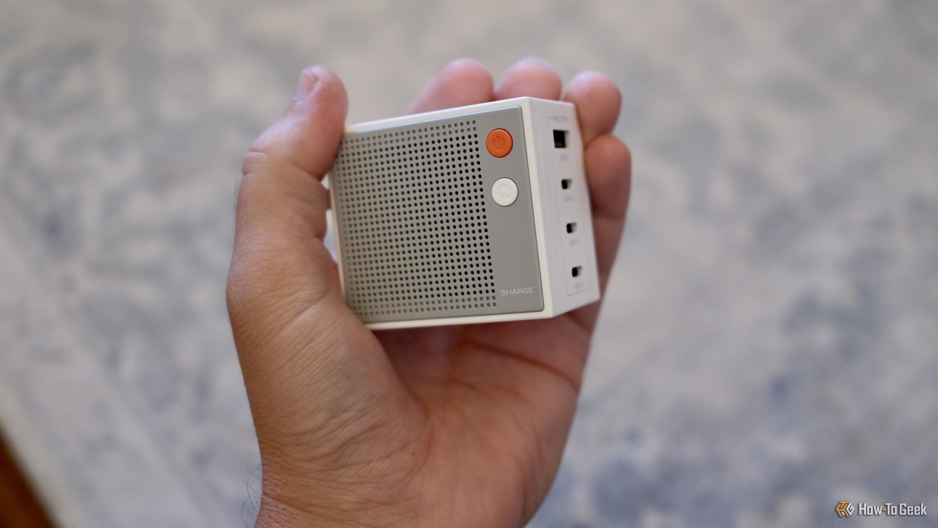 A person holding the Sharge Pixel 100 in their hand.