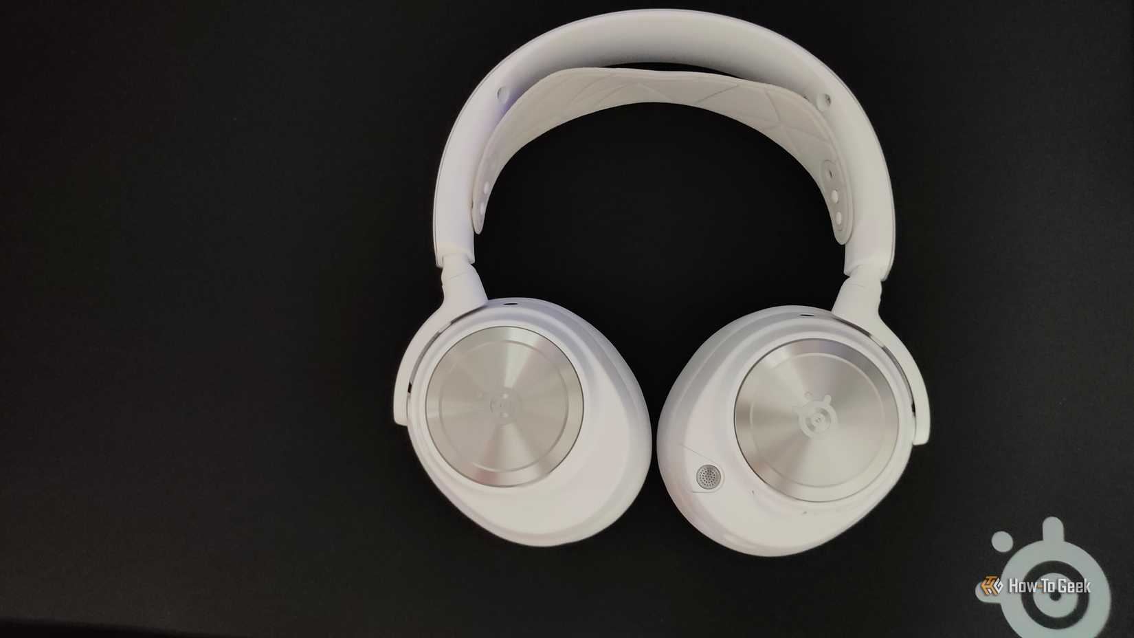 SteelSeries Arctis Nova Pro Wireless gaming headset on black SteelSeries mousepad.