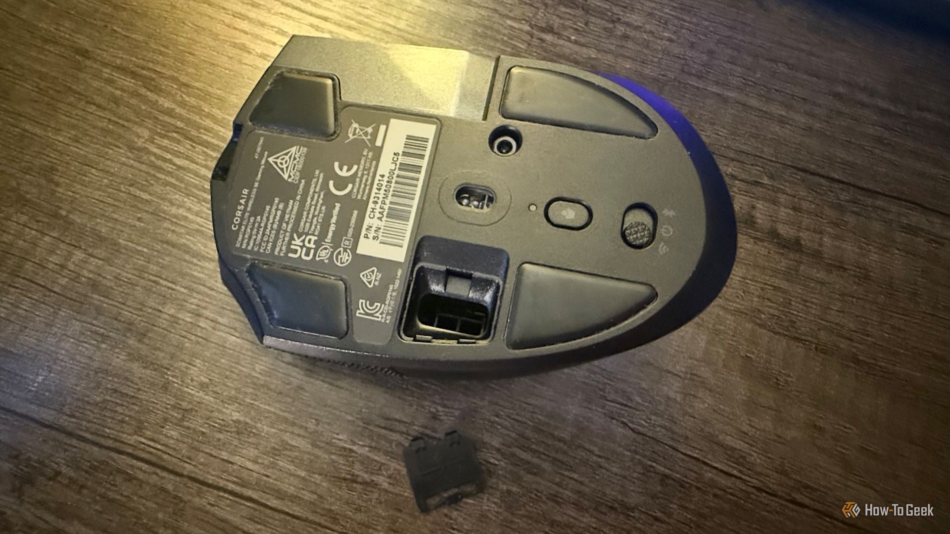The bottom of the Corsair Scimitar Elite Wireless SE with the 2.4 GHz receiver slot cover taken off.
