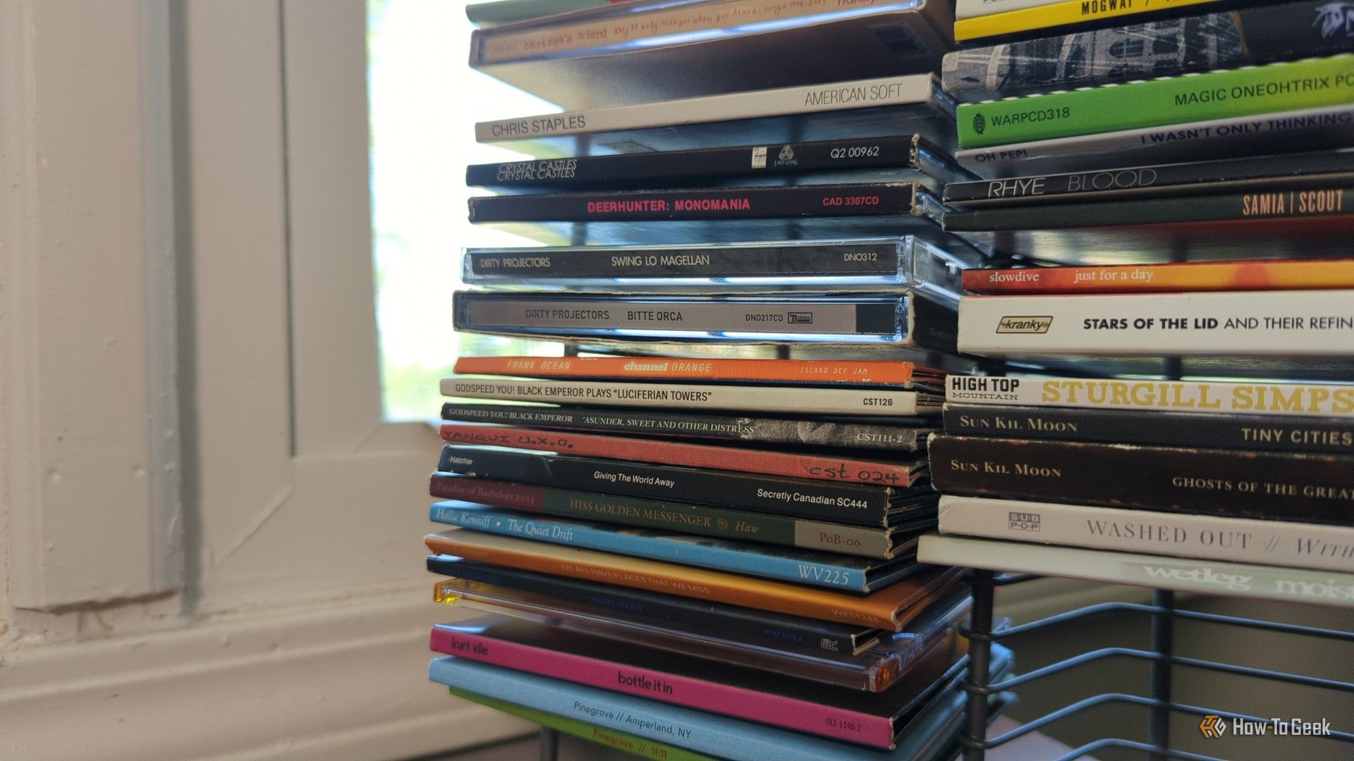 Several albums on a wire rack CD holder.