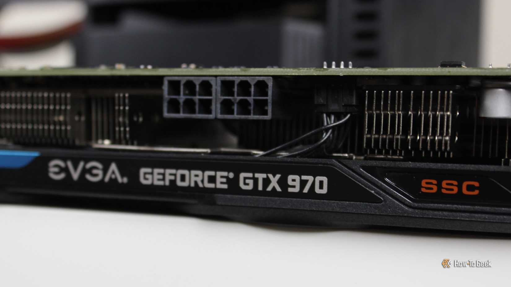The side of the EVGA NVIDIA GeForce GTX 970 SSC GAMING ACX 2.0 graphics card sitting on a desk.